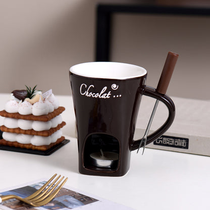 Chocolate-themed mug with a candle holder on a table with a cake and magazine.