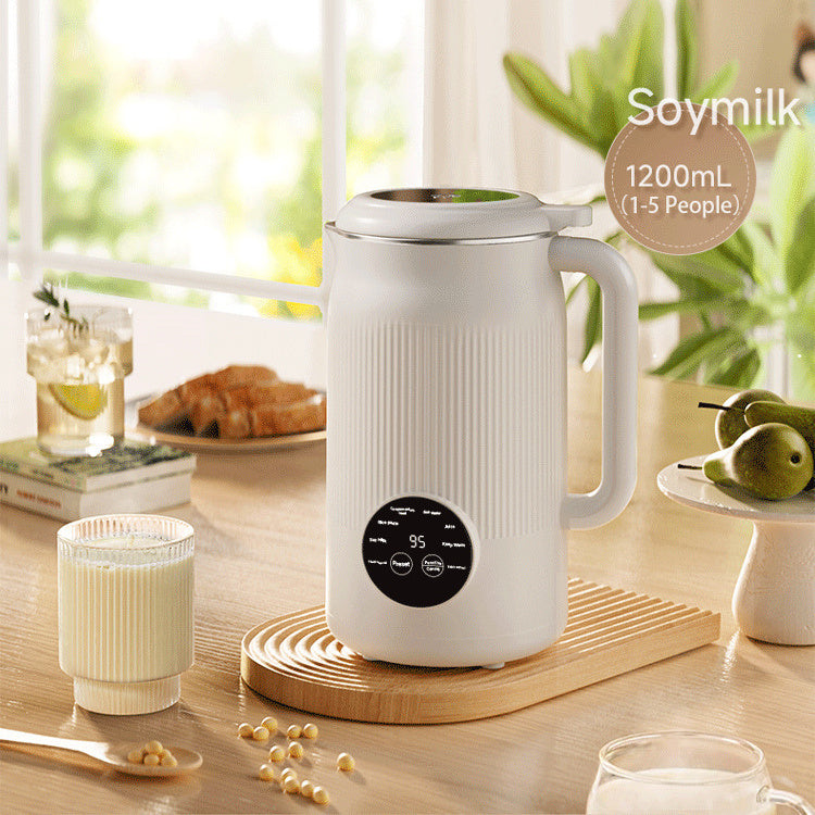 White soy milk maker on a wooden surface with a glass of soy milk and ingredients.
