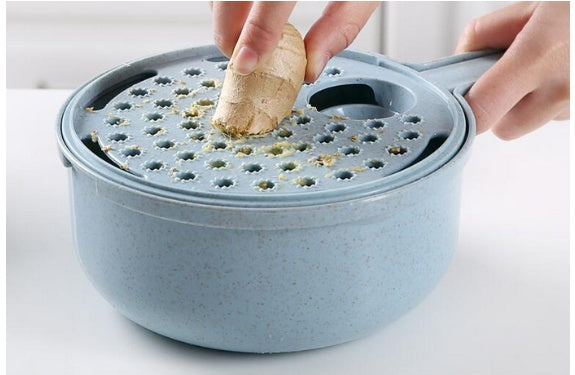 Blue ginger grater with a piece of ginger being grated on a white background