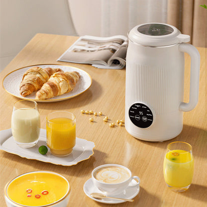 White electric kettle on a table with breakfast items including croissants, juice, and soup.