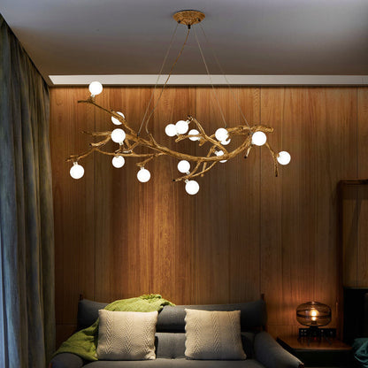 Modern chandelier with white lights hanging above a sofa in a room with wooden walls.