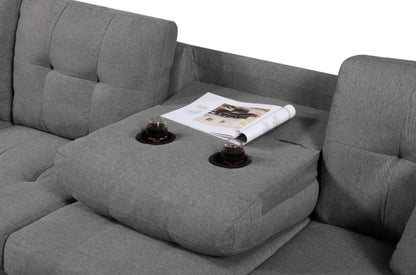 Gray sectional sofa with cup holders and a magazine on a light gray background