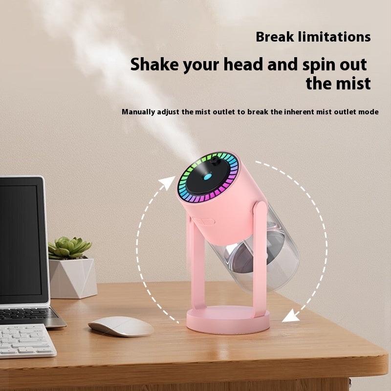 Pink handheld mist maker on a desk with text about its features