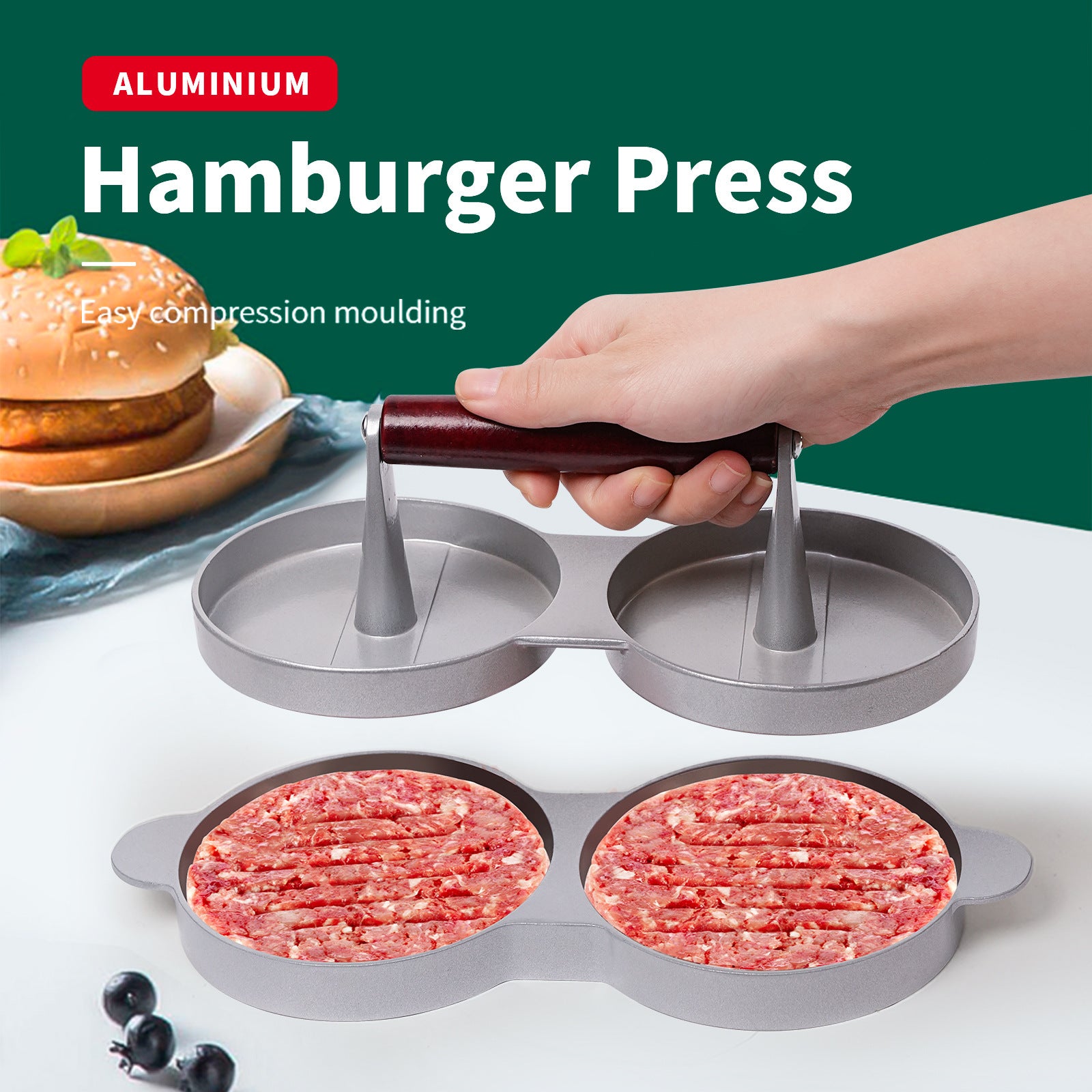 Hamburger press with ground meat patties on a white surface, next to a hamburger and blueberries.