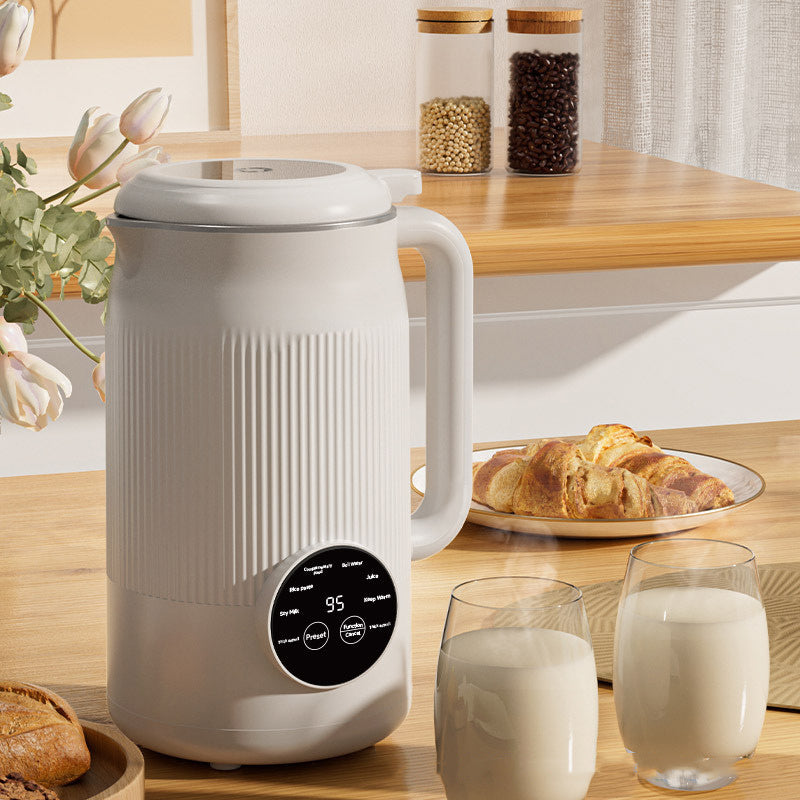 White electric kettle on a kitchen counter with glasses of milk and pastries.